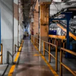 Interior pabrik modern dengan mesin produksi dan conveyor